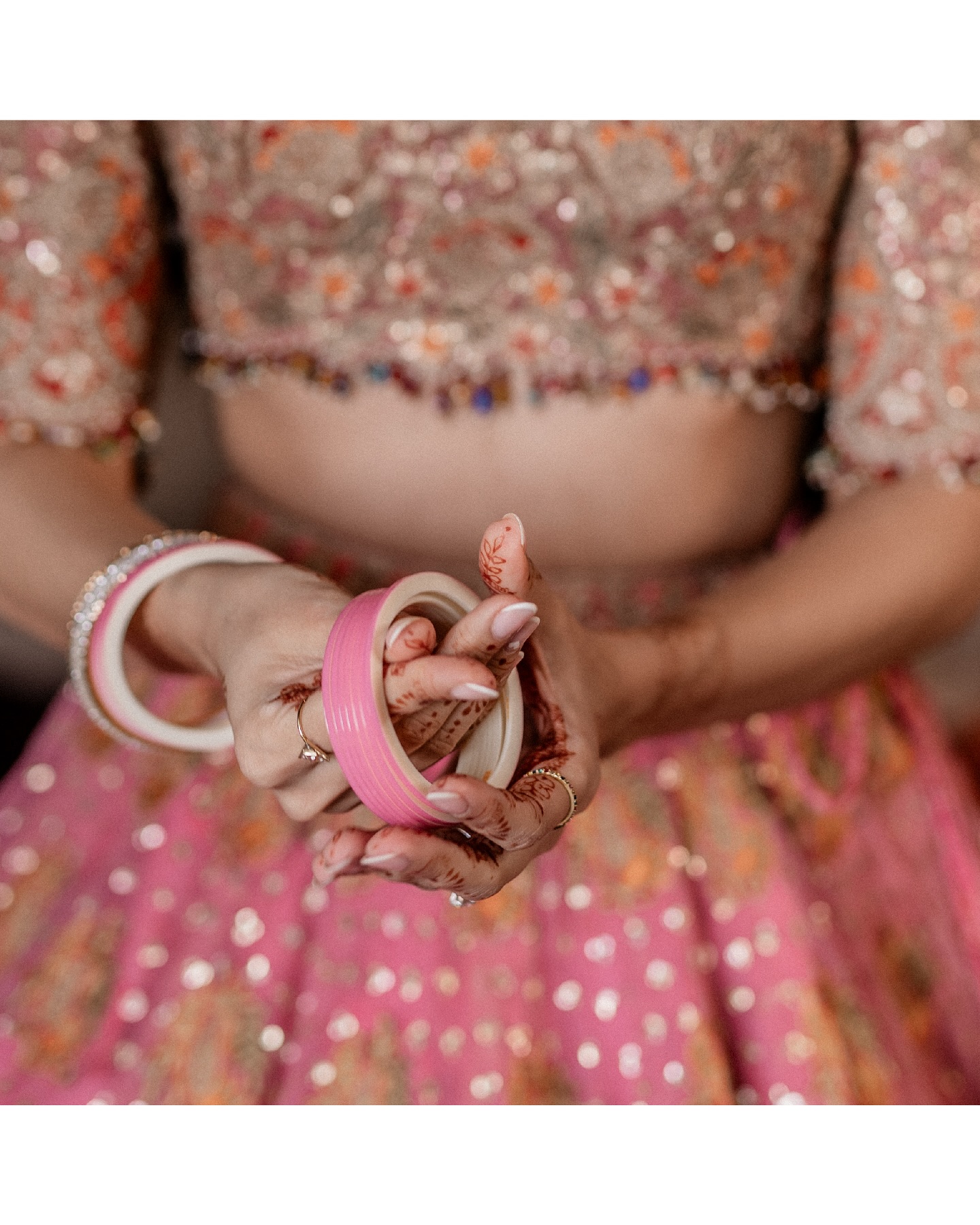 ✨In the soft glow of love, she stands draped in pastel pink, each intricate detail of her lehenga whispering tales of tr