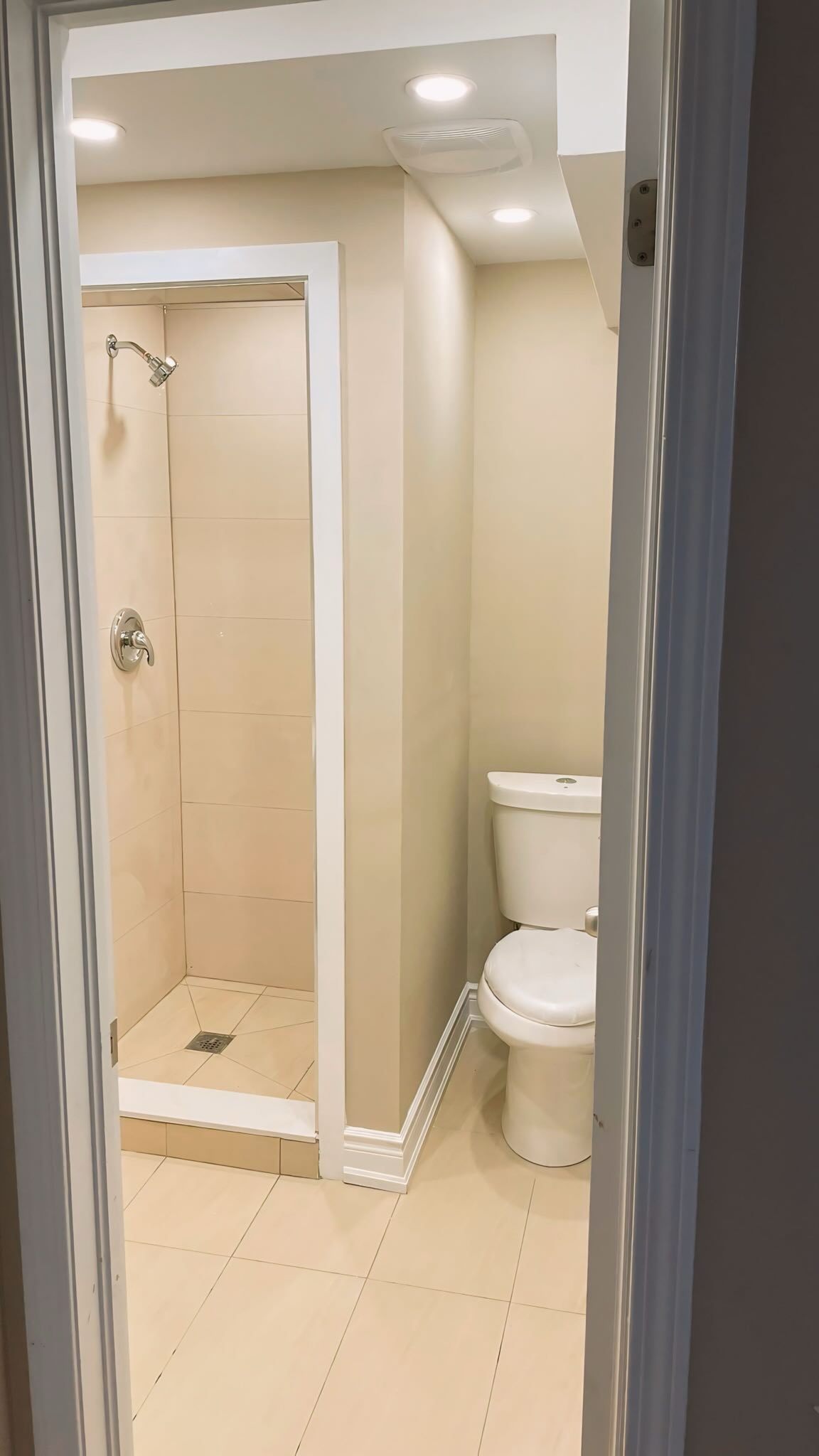 A clean bathroom installation for a custom basement renovation. From the bathroom tiling to the fixtures, everything is 