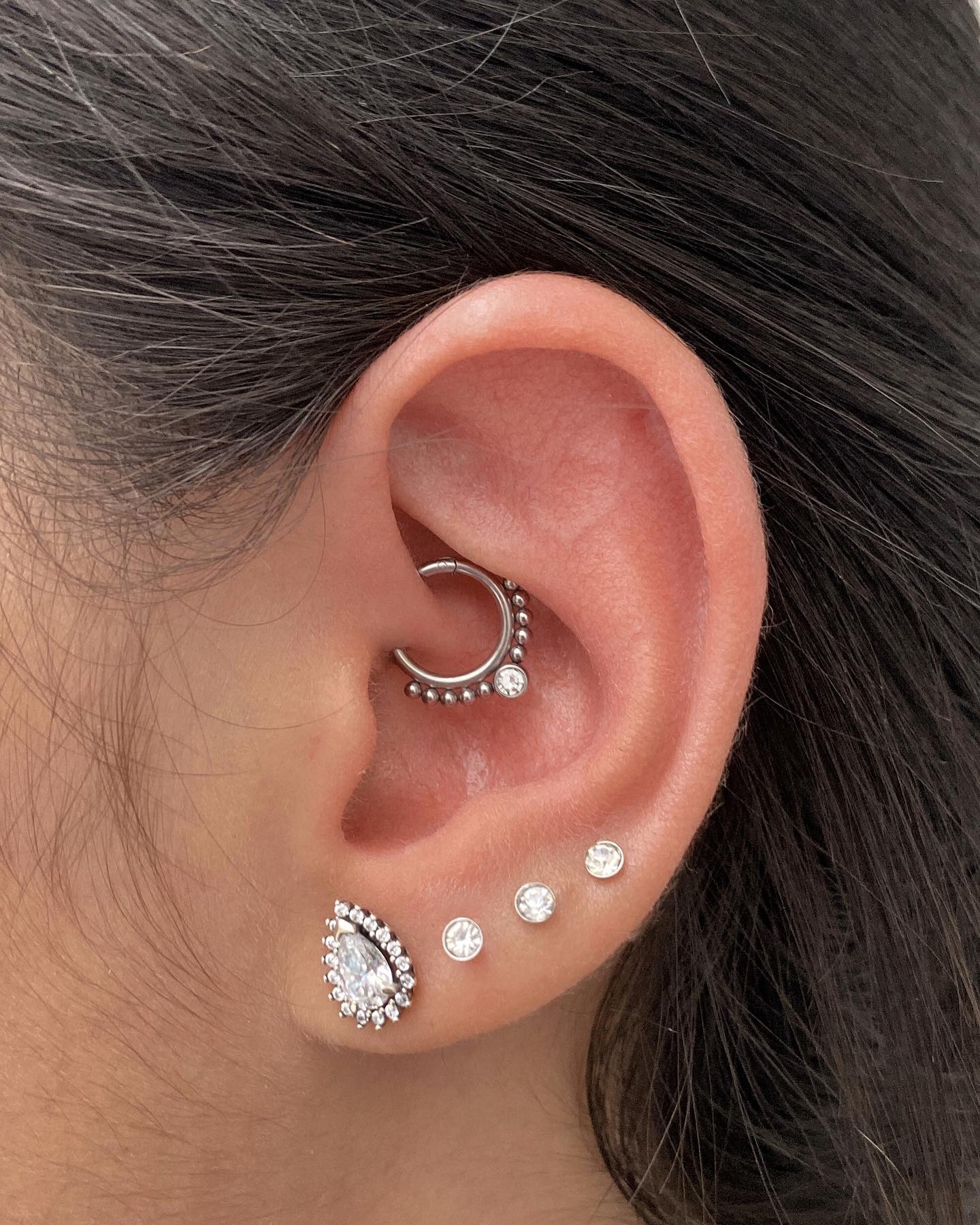 Un precioso Daith piercing que complementa un mega diseño en color plateado 🫶🏻🌙