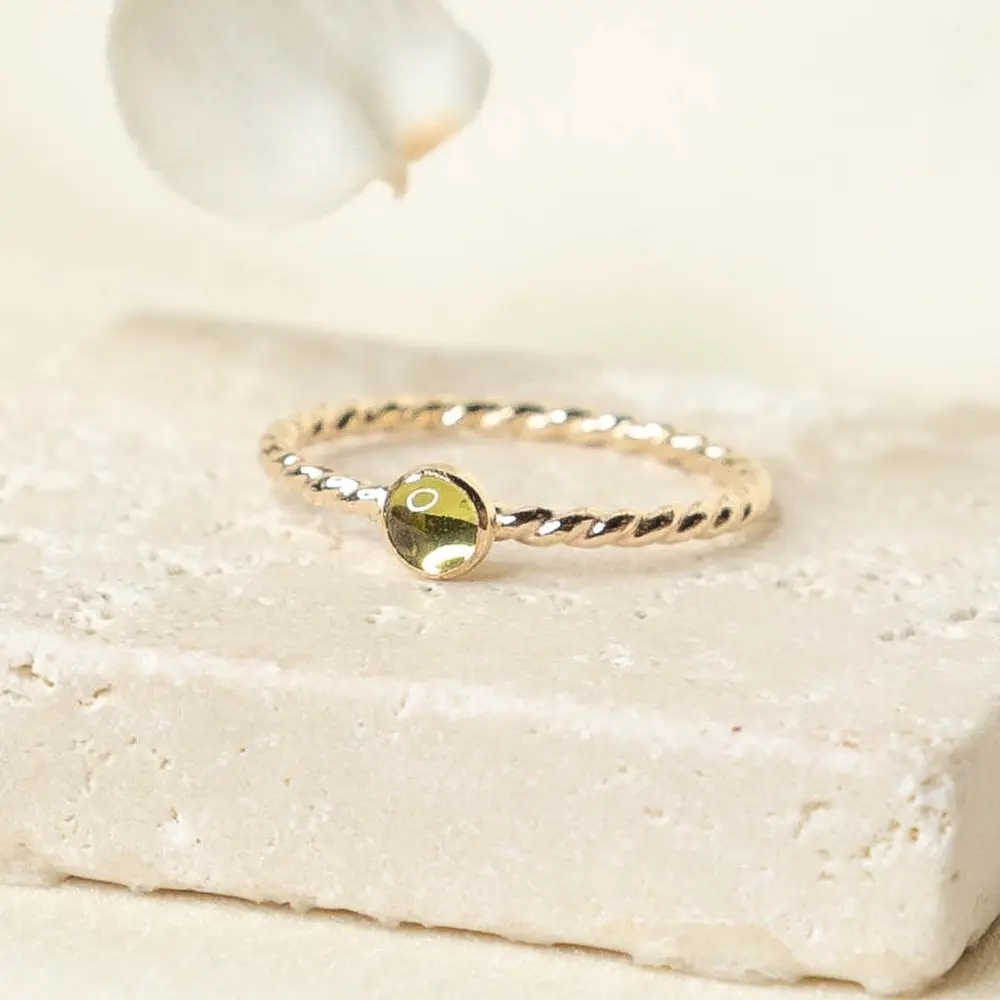 This beautiful ring is handcrafted by Aja Jewelry, with a twisted band that highlights the earthy peridot gem! The atten