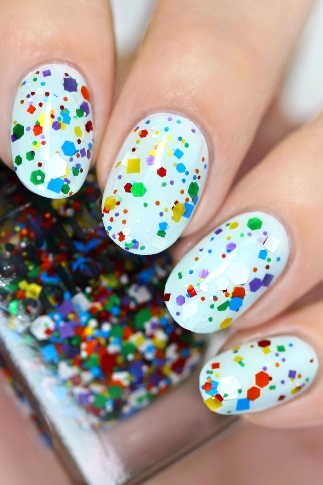 Bring the party with you! A rainbow iridescent flake nail polish topper with a clear base. Wear it on its own or on top 