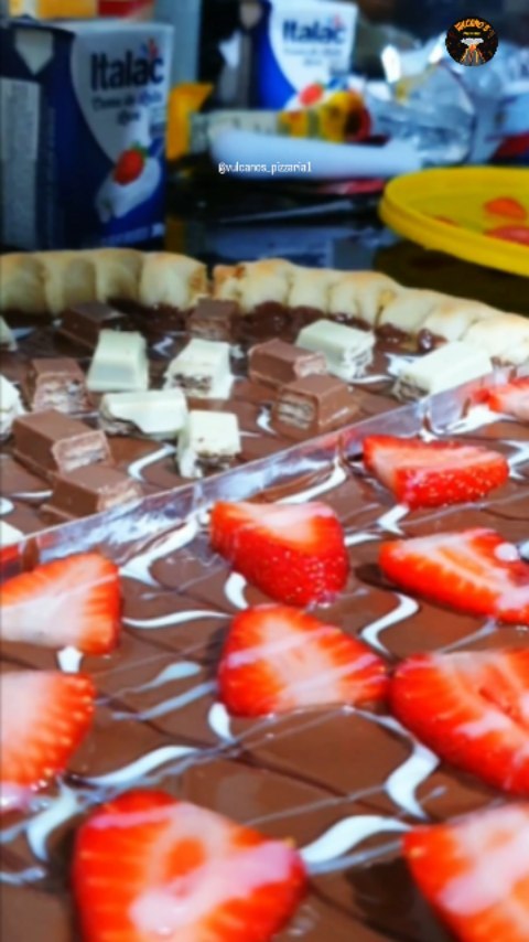 🍫🍓 Essa é para quem ama uma sobremesa de respeito! Metade da pizza vem coberta com pedaços crocantes de Kit Kat, e a out